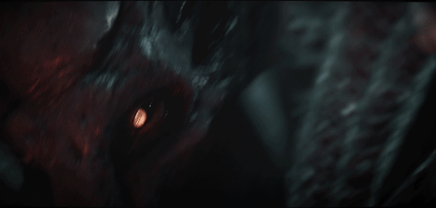 A zoom in on the eyes on a monstrous, tentacled face, looking panicked. The next shot is from their perspective, seen through the windshield of a vehicle, falling through the air, about to crash into the side of a mountain.